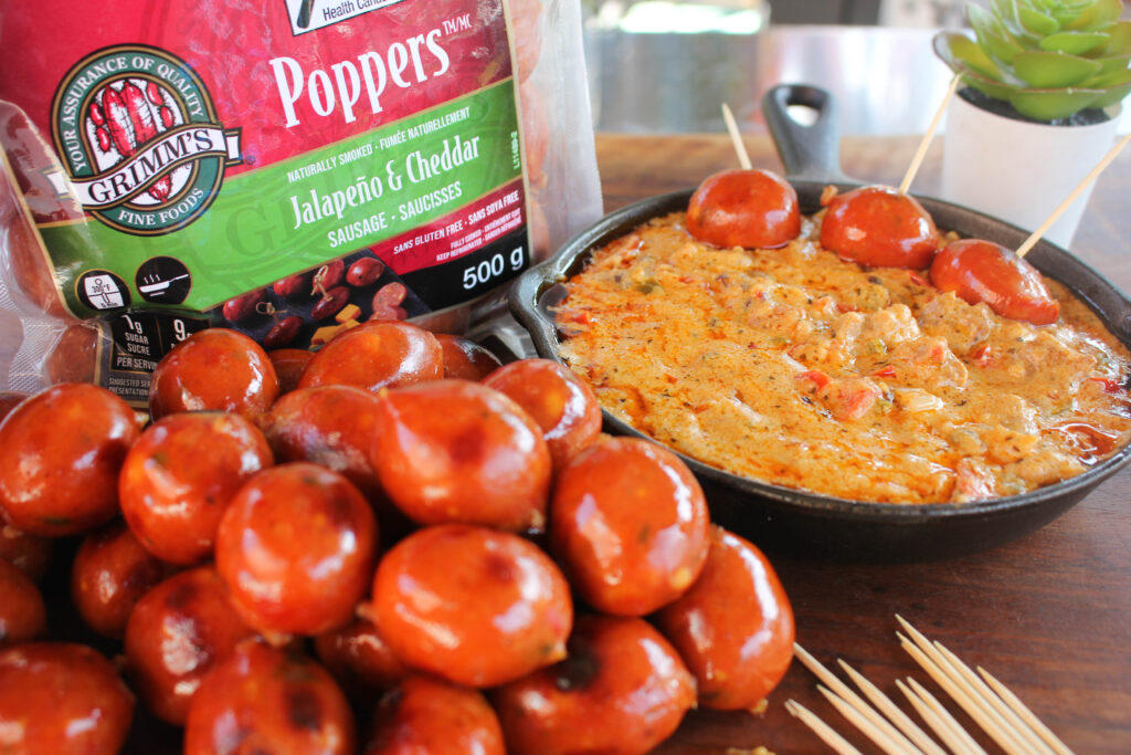 Jalapeno & Cheddar Poppers being dipped into queso